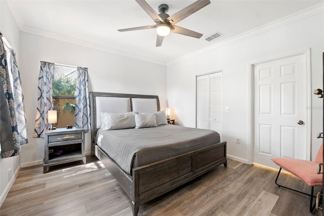 bedroom featuring crown molding, a closet, ceiling fan, and light wood-type flooring