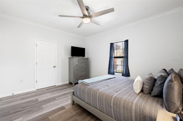 bedroom with ceiling fan, ornamental molding, and light hardwood / wood-style floors