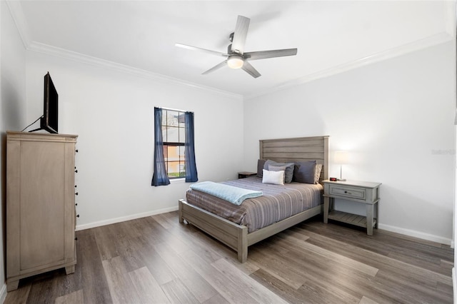 bedroom featuring hardwood / wood-style flooring, ceiling fan, and crown molding