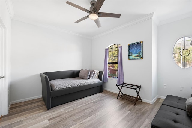 living room featuring ceiling fan, ornamental molding, and light hardwood / wood-style floors