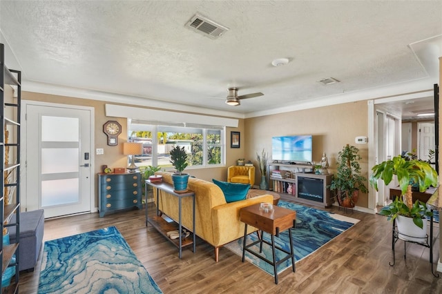 living room with ceiling fan, dark hardwood / wood-style floors, and a textured ceiling