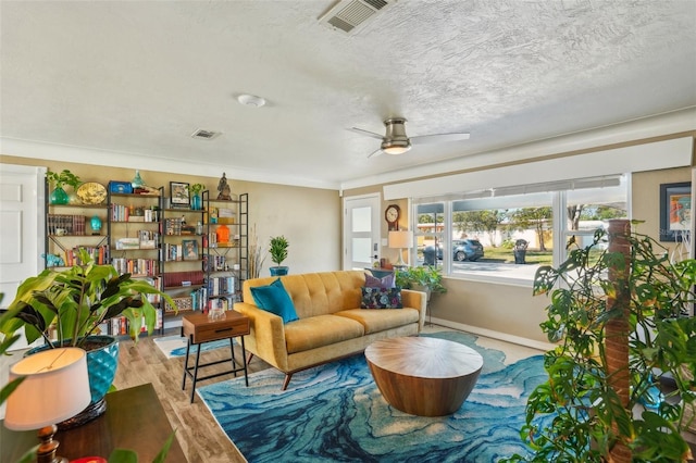 sitting room featuring ceiling fan, hardwood / wood-style floors, and a textured ceiling