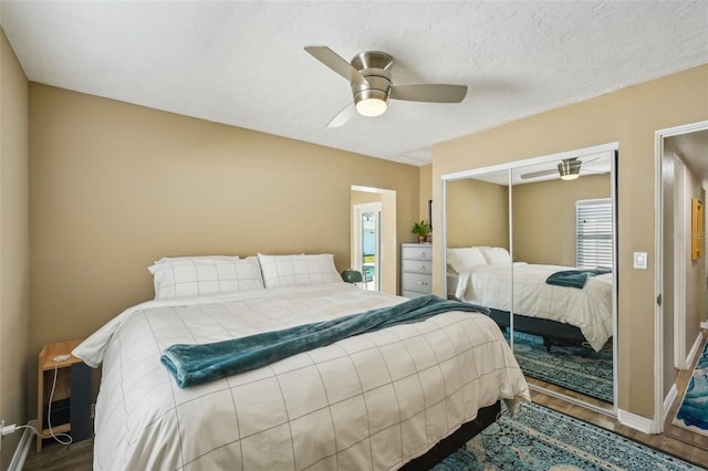 bedroom with dark hardwood / wood-style floors, a textured ceiling, ceiling fan, and a closet