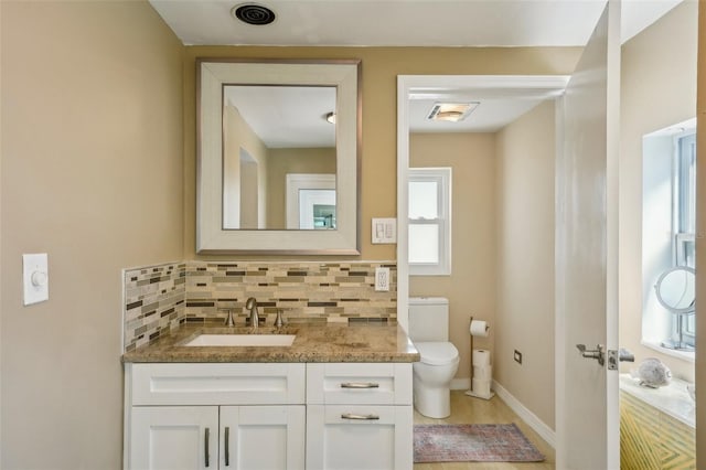 bathroom featuring vanity, backsplash, and toilet