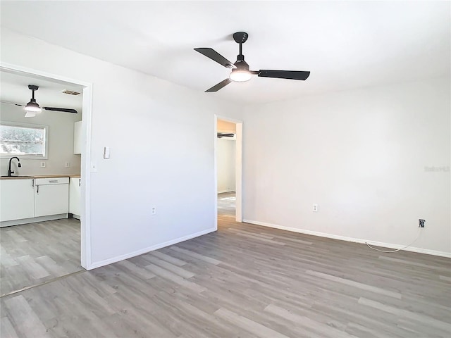 empty room featuring ceiling fan, light hardwood / wood-style floors, and sink