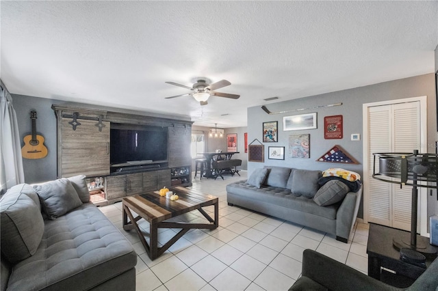 living room featuring light tile patterned floors, a textured ceiling, and ceiling fan