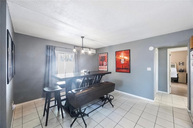 dining room with light tile patterned floors, a notable chandelier, and a textured ceiling