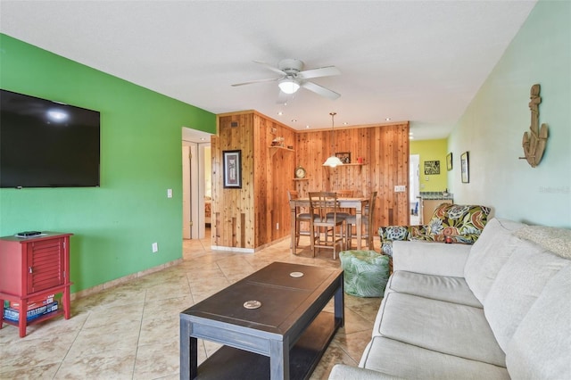 tiled living room featuring ceiling fan and wooden walls