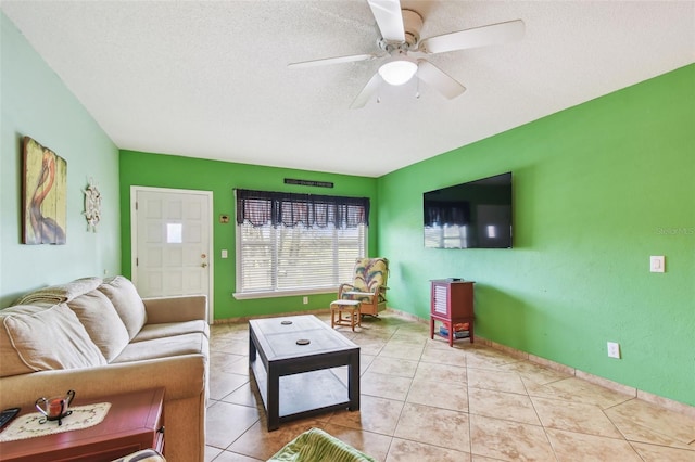 living room featuring ceiling fan, light tile patterned floors, and a textured ceiling