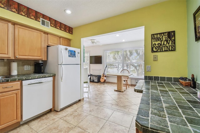 kitchen featuring ceiling fan, light tile patterned floors, white appliances, and decorative backsplash