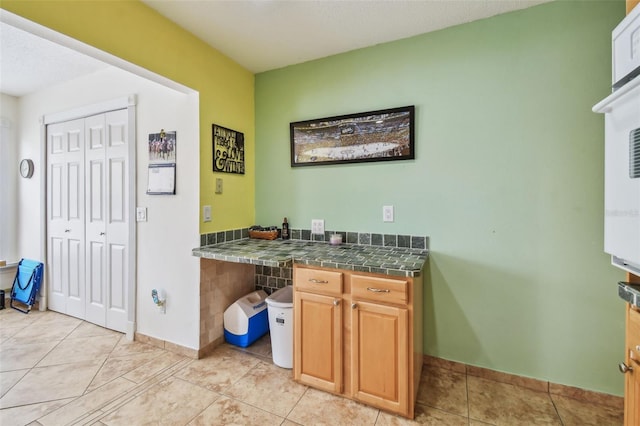 kitchen featuring light tile patterned flooring and tile countertops
