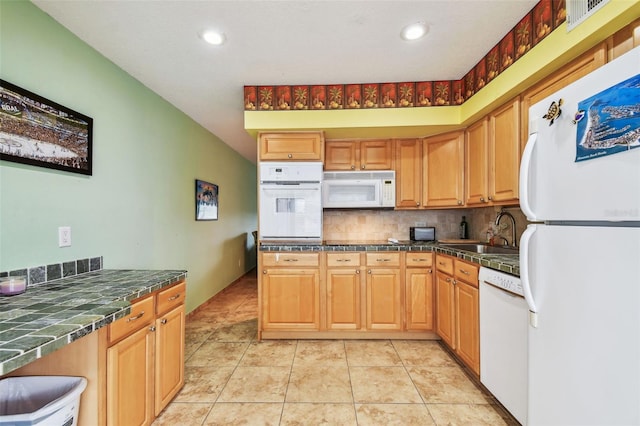 kitchen with tasteful backsplash, white appliances, light tile patterned flooring, and sink
