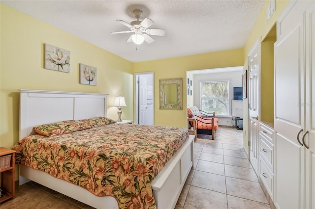 tiled bedroom with ceiling fan and a textured ceiling
