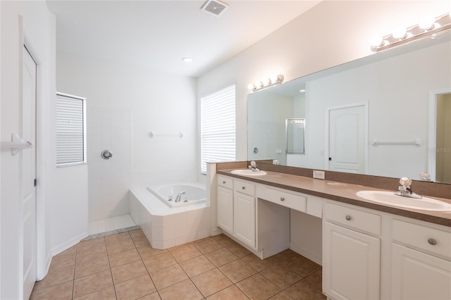 bathroom with tile patterned flooring, visible vents, double vanity, a bath, and a sink