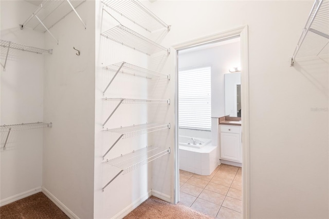 walk in closet with light tile patterned floors