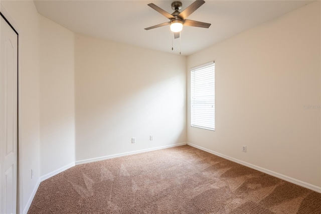 empty room featuring carpet flooring, a ceiling fan, and baseboards