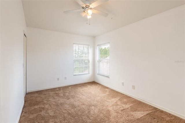 carpeted empty room featuring baseboards and ceiling fan