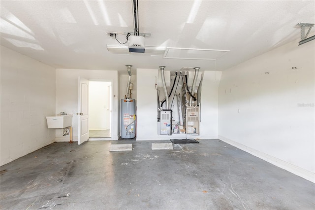 garage with water heater, concrete block wall, a garage door opener, and a sink