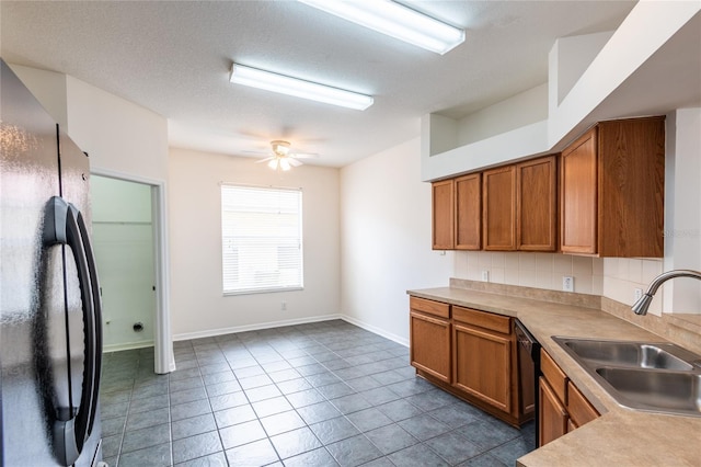 kitchen featuring backsplash, ceiling fan, brown cabinets, black appliances, and a sink