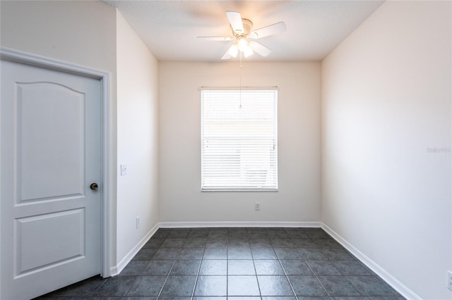 spare room featuring a ceiling fan and baseboards