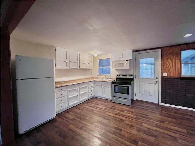 kitchen with white cabinetry, dark hardwood / wood-style floors, sink, and white appliances