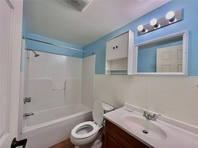 full bathroom with tile walls, vanity, shower / tub combination, and toilet