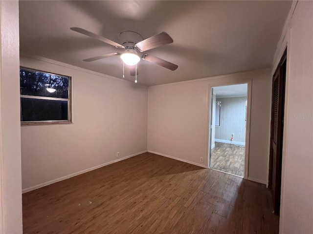 spare room with dark wood-type flooring and ceiling fan