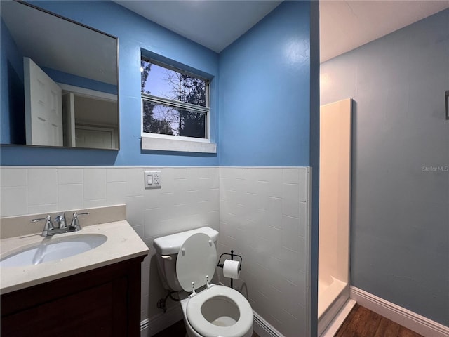 bathroom with walk in shower, vanity, toilet, and hardwood / wood-style floors