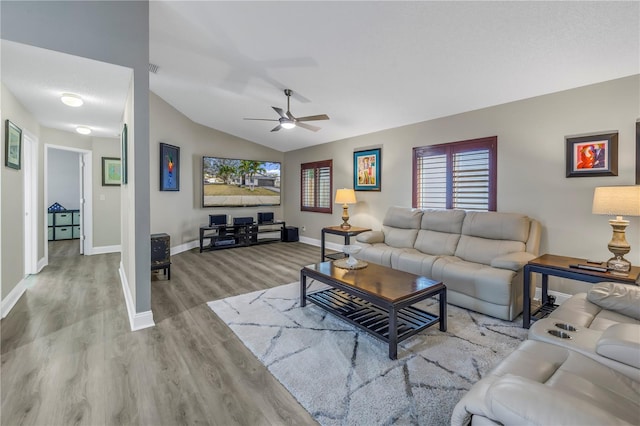 living room featuring light hardwood / wood-style flooring, ceiling fan, and vaulted ceiling