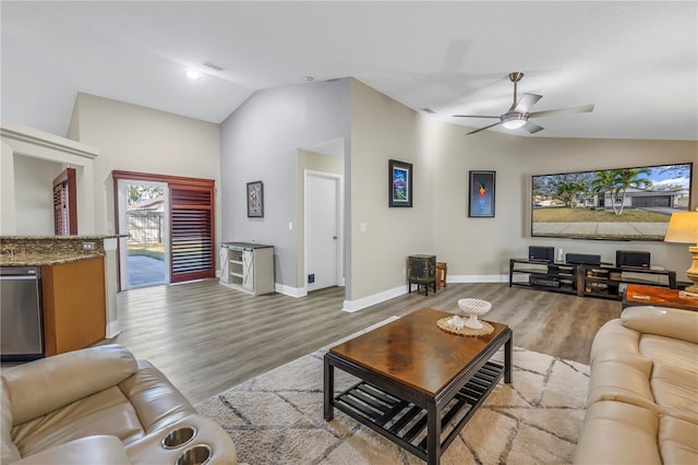 living room featuring ceiling fan, vaulted ceiling, and light wood-type flooring