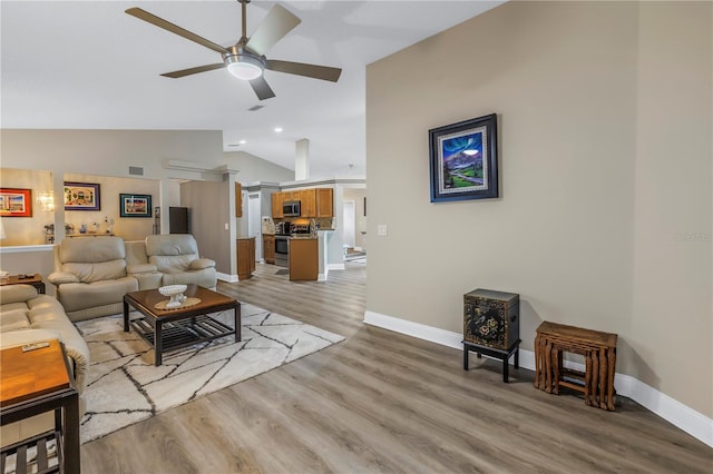 living room with ceiling fan, lofted ceiling, and light hardwood / wood-style flooring