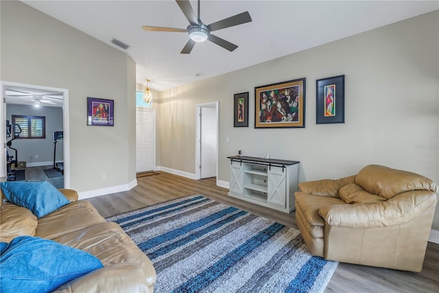 living room featuring hardwood / wood-style flooring, ceiling fan, and vaulted ceiling