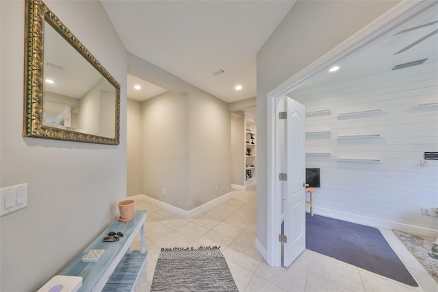 hall featuring light tile patterned floors, baseboards, and recessed lighting