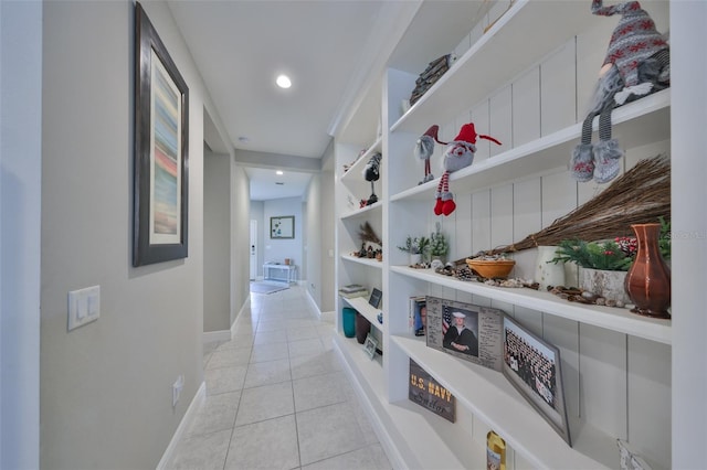 hallway with baseboards and light tile patterned floors