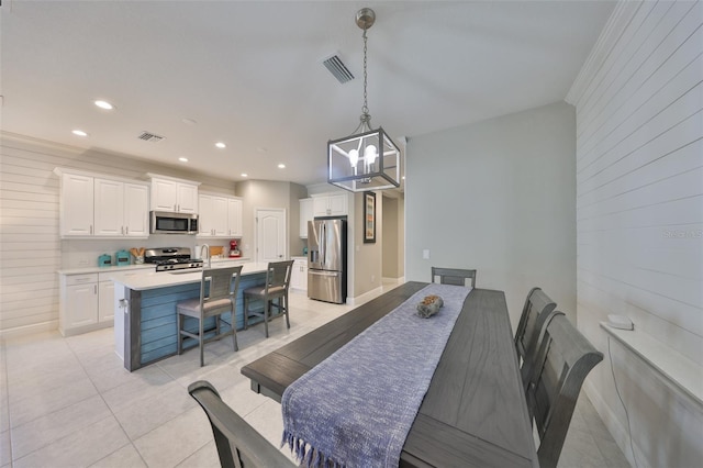 dining area with light tile patterned floors, wooden walls, visible vents, and recessed lighting