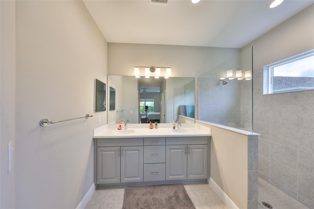 ensuite bathroom with double vanity, baseboards, ensuite bathroom, a walk in shower, and a sink