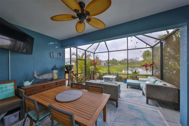 view of patio featuring a water view, an outdoor hangout area, a ceiling fan, outdoor dining space, and a lanai