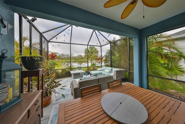 sunroom / solarium featuring a water view and a ceiling fan