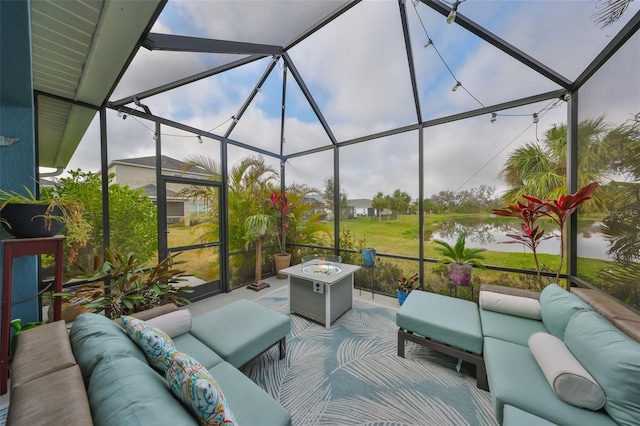 view of patio with a water view, an outdoor living space with a fire pit, and glass enclosure