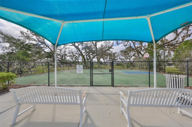 view of patio / terrace featuring a gate, community basketball court, and fence