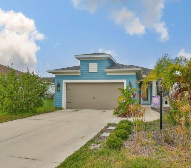 view of front facade with concrete driveway, fence, and an attached garage