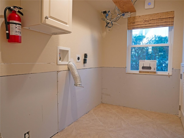 washroom with cabinets, washer hookup, hookup for an electric dryer, and light tile patterned floors