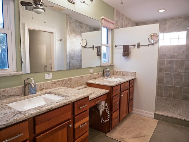 bathroom featuring tile patterned flooring, vanity, plenty of natural light, and tiled shower