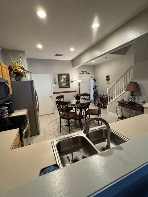 kitchen with appliances with stainless steel finishes, sink, and light brown cabinets