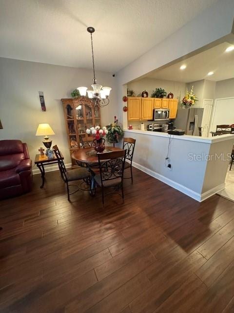 dining room featuring dark wood-type flooring and an inviting chandelier