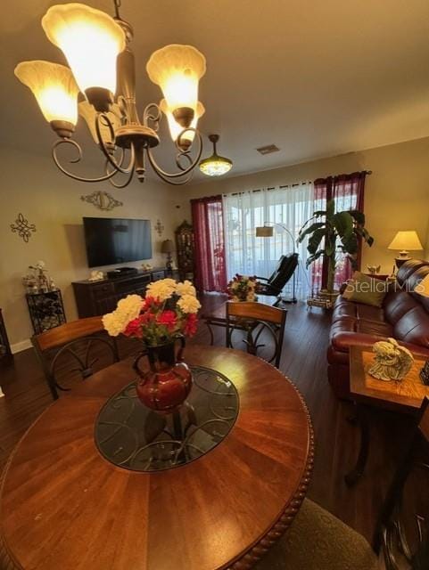 dining space featuring dark hardwood / wood-style floors and a chandelier