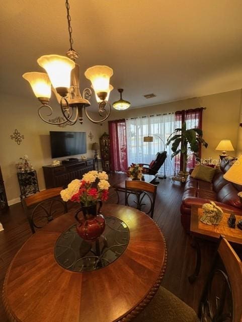 dining space featuring dark hardwood / wood-style flooring and a chandelier