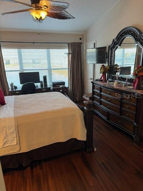 bedroom with ceiling fan, dark hardwood / wood-style floors, and vaulted ceiling