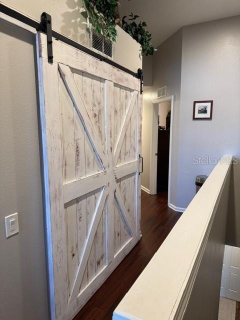 interior space with wood-type flooring and a barn door