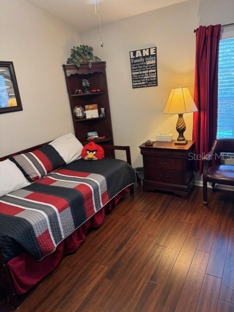 bedroom with dark hardwood / wood-style flooring